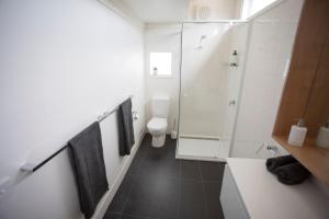 a bathroom with a toilet and a glass shower at Monrepos in Point Lonsdale