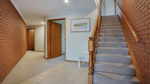 a staircase in a house with a brick wall at SeaLeka 3 in Merimbula