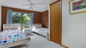 a bedroom with two beds and a window at SeaLeka 3 in Merimbula