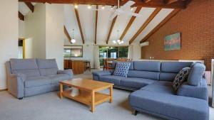 a living room with two blue couches and a coffee table at SeaLeka 3 in Merimbula