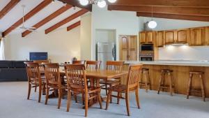 a kitchen and dining room with a wooden table and chairs at SeaLeka 3 in Merimbula +11 photos