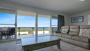 a living room with a couch and a table at Quarterdeck 3 in Tura Beach