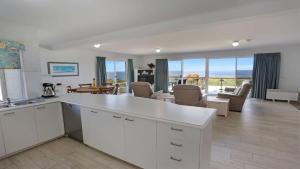 a kitchen and living room with a view of the ocean at Quarterdeck 3 in Tura Beach