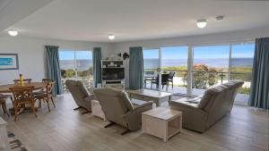 a living room with a couch and chairs and a table at Quarterdeck 3 in Tura Beach