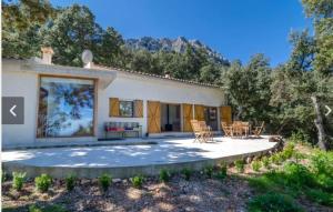 a house with a patio with chairs and trees at Sa Talaia in Lluc