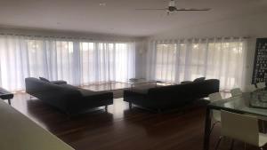 a living room with two couches and a table at Turaroo in Tura Beach