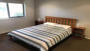 a bedroom with a bed with two pillows and a window at Turaroo in Tura Beach +5 photos