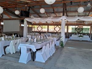 a banquet hall with white tables and white chairs at Agro Camping Los Costeños in Choapa