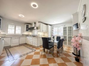 a kitchen with white cabinets and a table and chairs at Sunset Marbella in Marbella