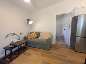 a living room with a couch and a refrigerator at Elm's Deep Guest House in Berridale