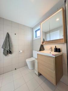 a bathroom with a sink and a toilet and a mirror at Elm's Deep Guest House in Berridale +13 photos