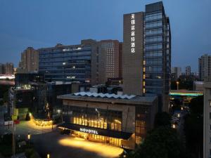 a view of a building in a city at night at Novotel Wuxi in Wuxi