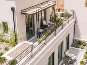 a balcony with chairs and a table on a building at Athens Capital Suites-MGallery Collection in Athens