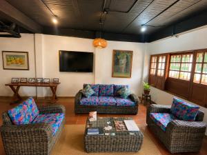 a living room with a couch and chairs and a tv at Yeshca Hotel Boutique in Villa de Leyva