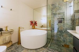 a bathroom with a tub and a glass shower at The Advocate in Martinborough +6 photos