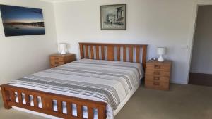 a bedroom with a large bed and two night stands at Coastal Escape in Tura Beach