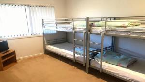 a room with two bunk beds and a television at Coastal Escape in Tura Beach +6 photos