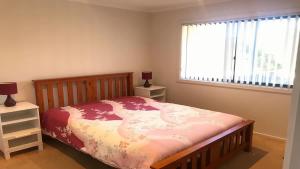 a bedroom with a bed and a window at Coastal Escape in Tura Beach