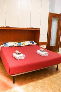 a bedroom with a red bed with towels on it at Sanremo Apartments - Ortensia in Sanremo