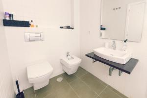 een witte badkamer met een toilet en een wastafel bij Modern Apartment - Alicante in Alicante