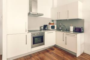 een keuken met witte kasten en een fornuis bij Modern Apartment - Alicante in Alicante