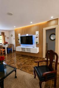 a living room with a flat screen tv on a wall at spring house jarabacoa bbq ,piscina privada, Wi-Fi deco 10 huéspedes 3 baños, 2 aires A C 4 habitaciones in Jarabacoa