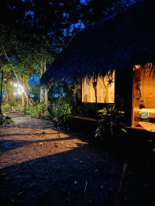 a small shack with a thatched roof at night at Nawala Eco-hostel in Termales - agua caliente - nuqui