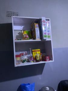 a shelf with food and other food items on it at Kaunda Home in Blantyre