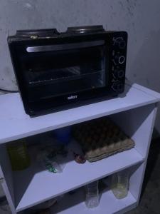 a black microwave sitting on top of a shelf at Kaunda Home in Blantyre