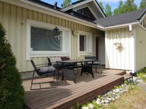 a wooden deck with a table and chairs on it at Holidayhome RintintinTahko in Tahkovuori