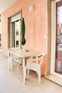 a white table and chairs with a plant on it at Sanremo Apartments - Ortensia in Sanremo