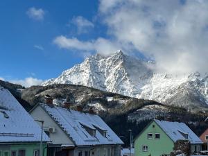 a snow covered mountain in the distance with houses at Panoramic Alpine Residence in Eisenerz