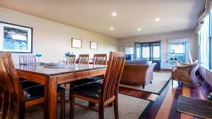 a dining room with a wooden table and chairs at Bantry Two in Merimbula