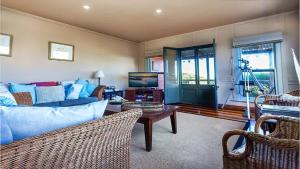 a living room with a blue couch and a television at Bantry Two in Merimbula