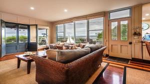a living room with a couch and chairs and windows at Bantry Two in Merimbula +9 photos