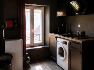 a kitchen with a washing machine and a window at ღ Love Room intime - Sauna - Hmm OH Oui ღ in Saint-Quentin +20 photos