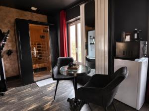a room with a table and two chairs and a refrigerator at ღ Love Room intime - Sauna - Hmm OH Oui ღ in Saint-Quentin