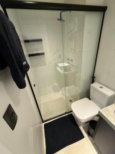 a bathroom with a toilet and a glass shower at Flat completo e aconchegante em Caruaru in Caruaru +27 photos