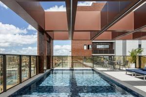 an indoor swimming pool in a building with a view at Flat completo e aconchegante em Caruaru in Caruaru