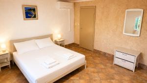 a bedroom with a white bed and two night stands at Private Vineyard House in Banjol