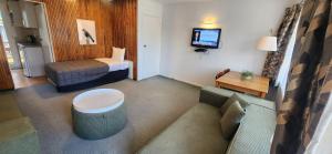 a hotel room with a couch and a bed at Aalton Motel in Christchurch