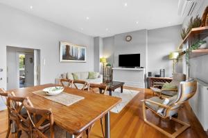 a living room with a wooden table and chairs at Pelicans at the Ozone in Queenscliff