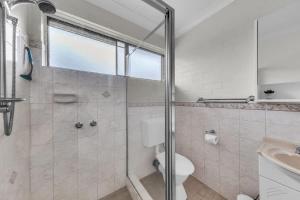 a bathroom with a shower and a toilet and a sink at Hydra 8 in Merimbula