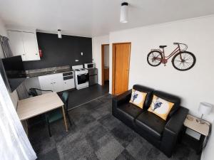 a living room with a couch and a bike hanging on the wall at Forest Peak Motel in Hanmer Springs