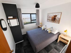 a bedroom with a bed and a picture of a cow at Forest Peak Motel in Hanmer Springs
