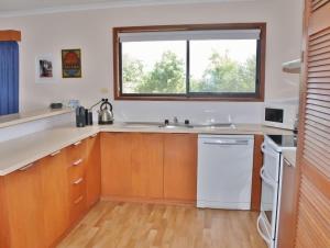 a kitchen with a sink and a window at Laura's Pambula Beach in Pambula Beach