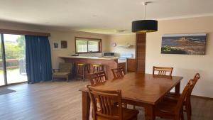 a dining room and kitchen with a table and chairs at Laura's Pambula Beach in Pambula Beach