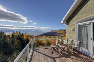 a deck with chairs and a view of the mountains at 2CH - Fireplace Panoramic View - Upper Unit in Petite-Rivière-Saint-François