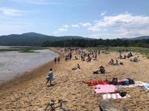 a group of people sitting on a beach at 2CH - Fireplace Panoramic View - Upper Unit in Petite-Rivière-Saint-François