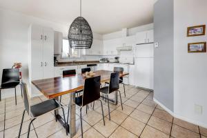 a kitchen with a wooden table and black chairs at 2CH - Fireplace Panoramic View - Upper Unit in Petite-Rivière-Saint-François